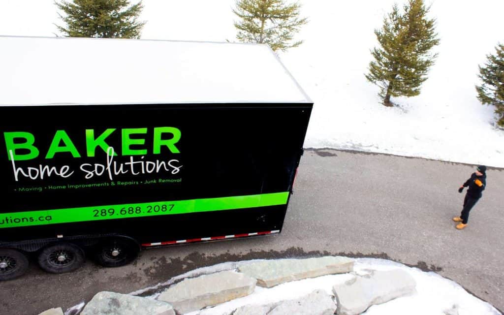 Baker Home Solutions truck parked outdoors with snow, offering home repairs and renovation services.
