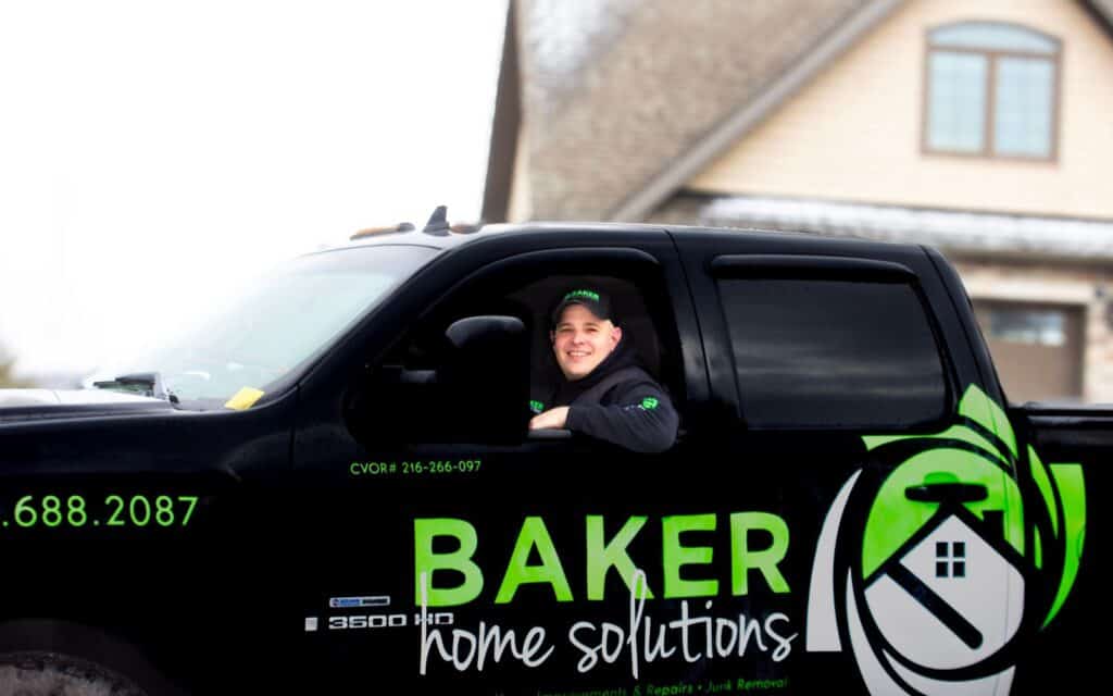 Alt: Professional home repair technician in a BAKER Home Solutions truck, ready for service.