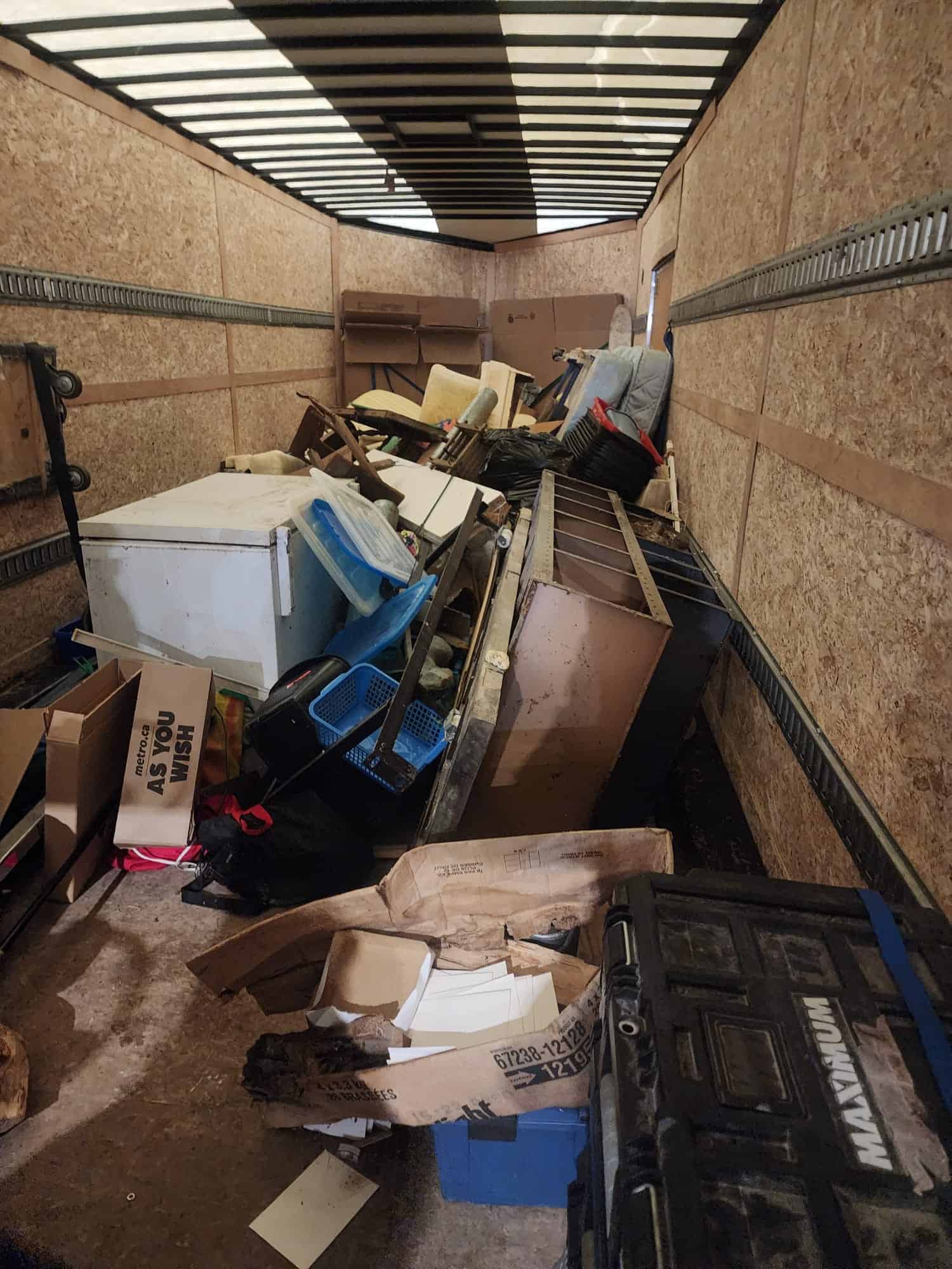 Cluttered moving truck filled with furniture and boxes for home renovation.