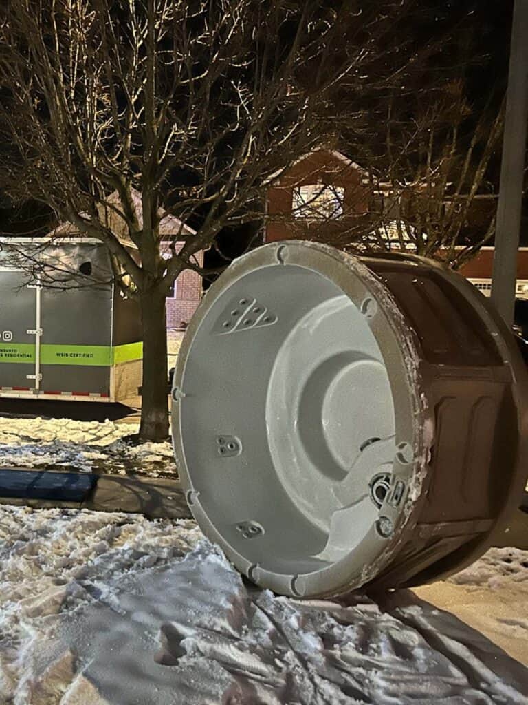 Outdoor electrical meter box on snowy ground at night.