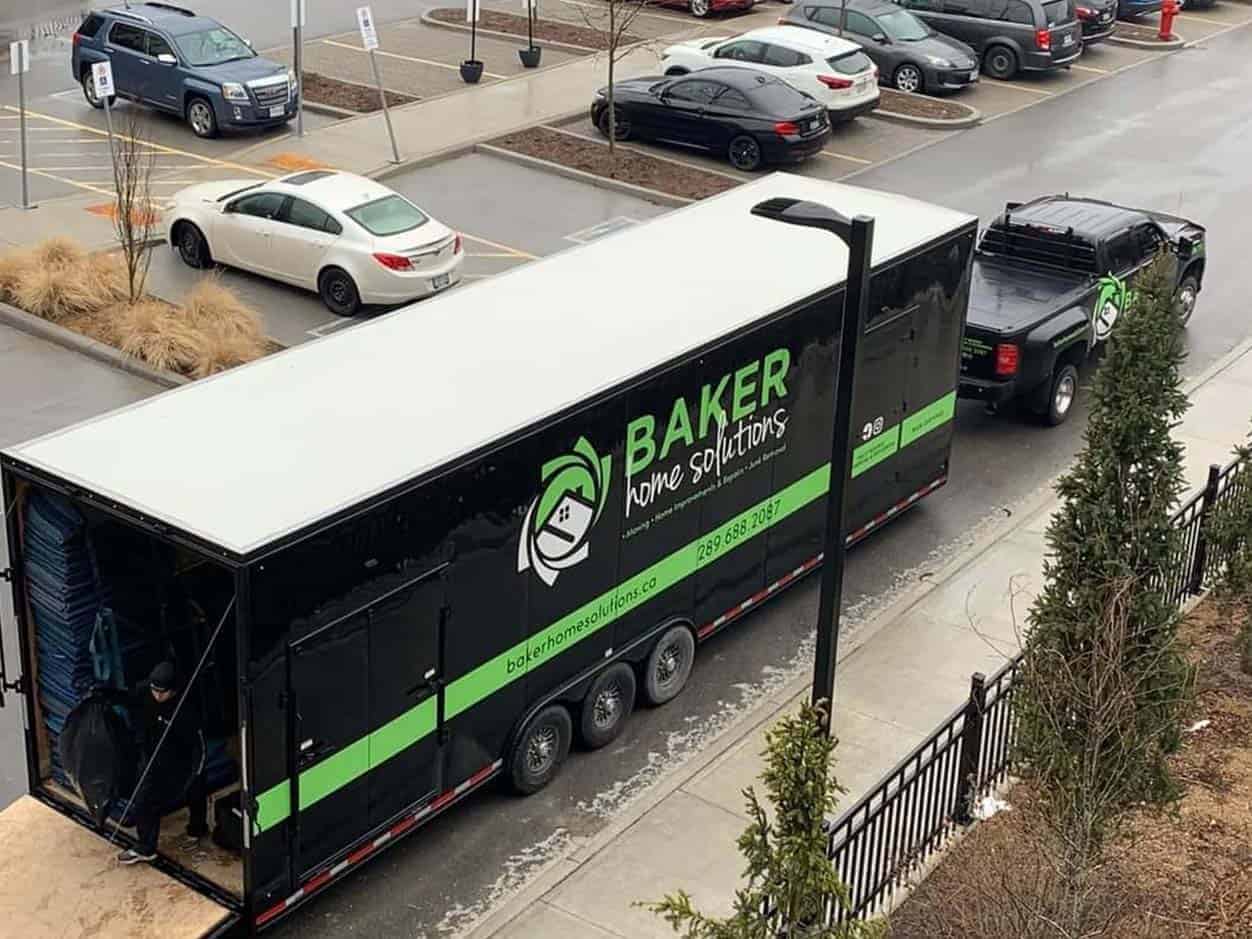Baker Home Solutions delivery truck parked on city street in daytime.