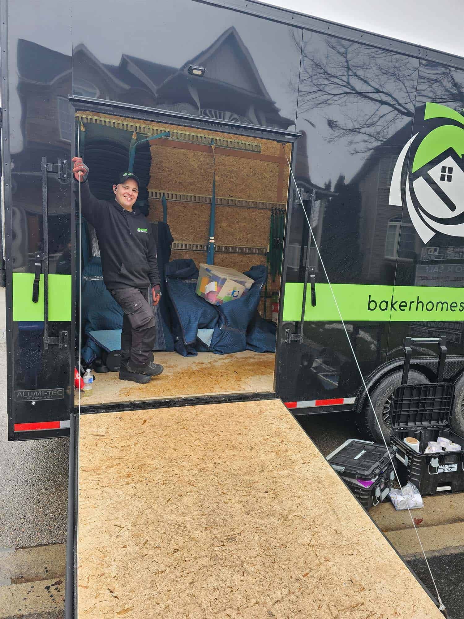Skilled worker at Baker Home Solutions loading tools into a mobile workshop.